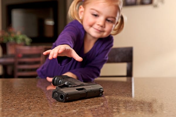 image of a young girl reaching for the gun