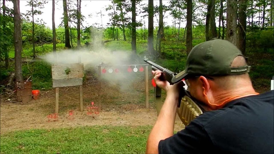 image of a man using a shotgun for target shooting