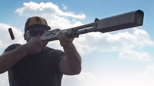 image of a man using a shotgun suppressor in shooting