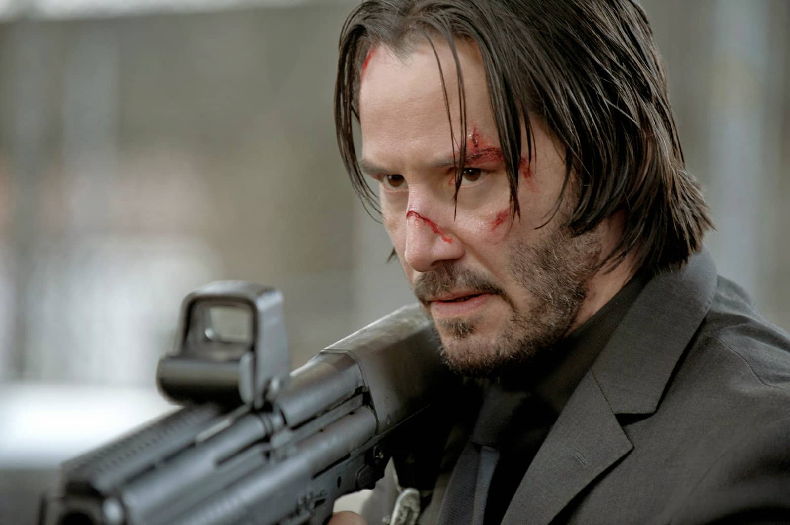 Keanu Reeves playing John Wick holding a shotgun
