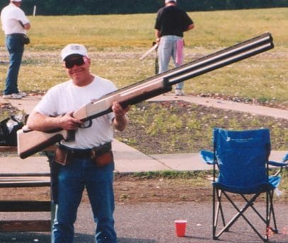 Picture of a man holding an extremely big rifle
