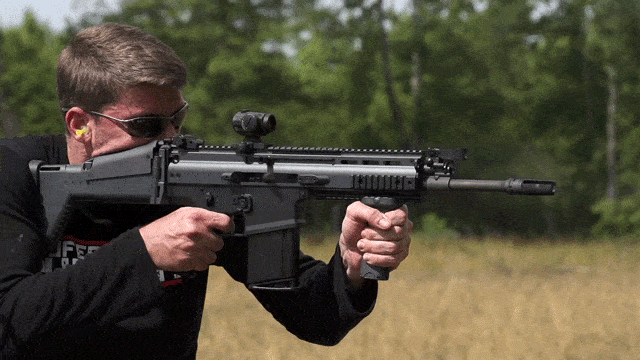 civilian shooting an ar15 with 16 inch barrel in field - slow motion gif