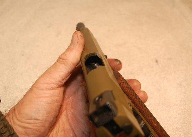 man checking the 1911 barrel with slide back to make sure its empty in 2017