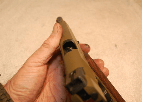Checking the 1911 barrel with slide back to make sure its empty