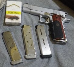 a picture of a hardchromed 1911 with three magazines