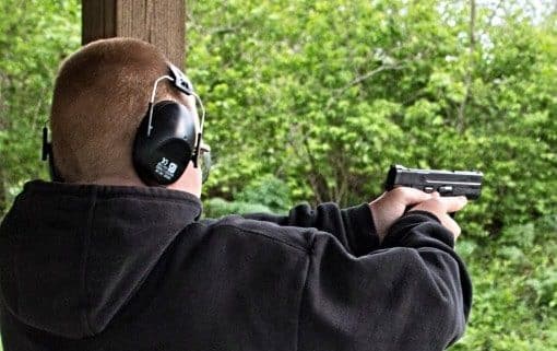 image of a man equipped with Hearing Protection while shooting