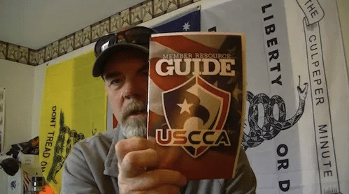 Man holding a USCCA Guide up